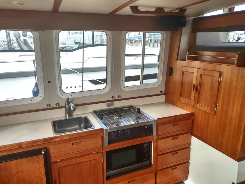Slide: The Image of Interior of 2005 Nordic Tug 32 with kitchen and windows. - 32