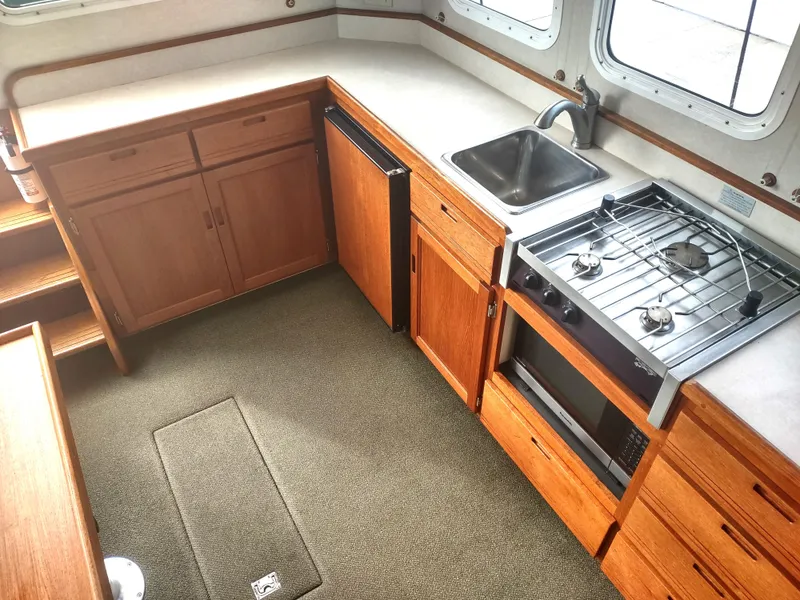 Slide: The Image of Interior of 2005 Nordic Tug 32 featuring kitchen and stove. - 33