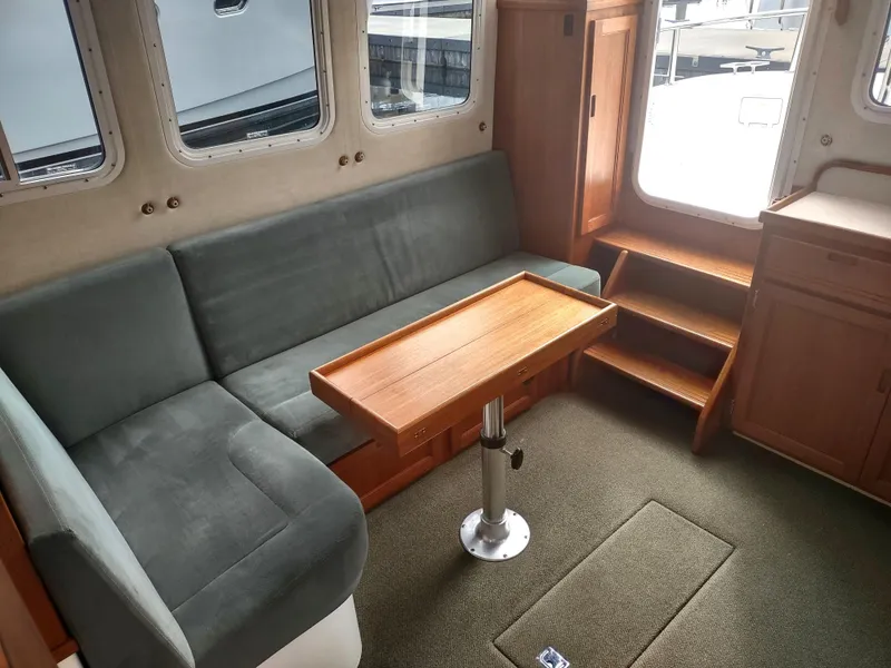 Slide: The Image of Interior of a 2005 Nordic Tug 32 with gray sofa and wooden table. - 41