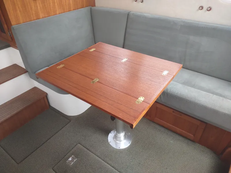 Slide: The Image of Interior of a 2005 Nordic Tug 32 with wooden table and gray upholstered bench. - 42