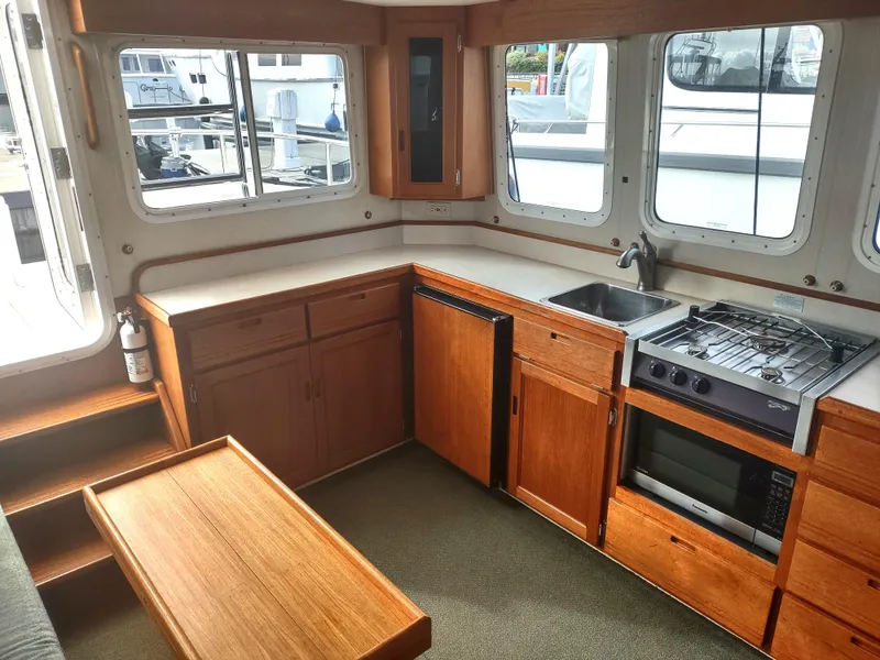 Slide: The Image of Interior of 2005 Nordic Tug 32 with kitchen and wood paneling. - 43