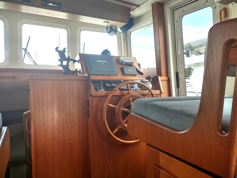 Slide: The Image of Interior view of a 2005 Nordic Tug 32 helm with wooden finish. - 49