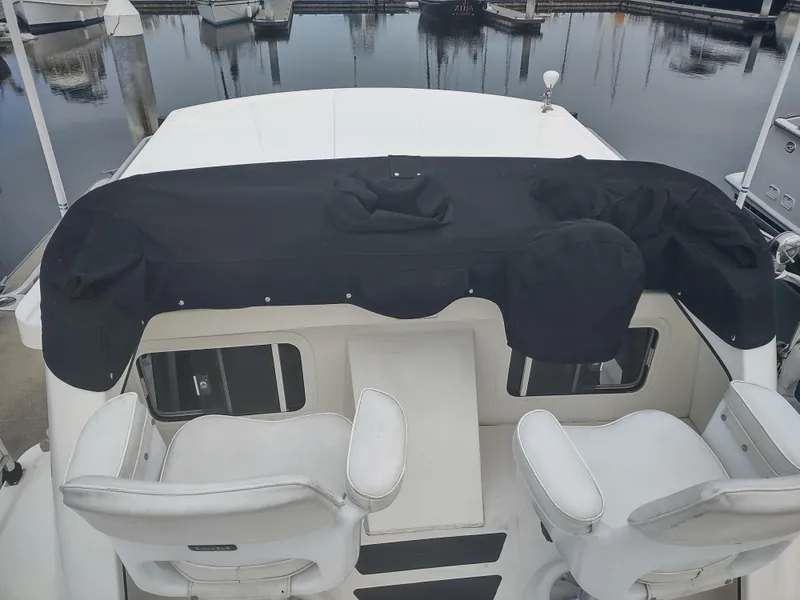 Slide: The Image of 2005 Nordic Tug 32 with black cover docked at marina. - 7