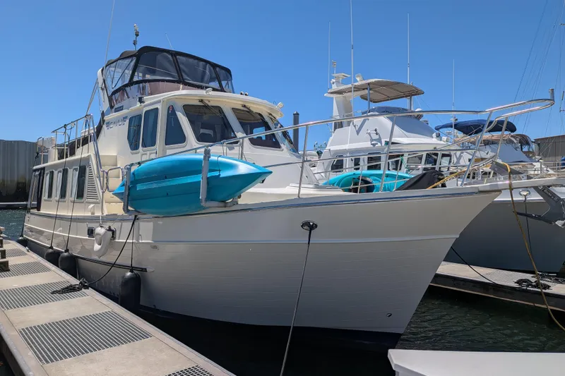 Slide: The Image of 2006 North Pacific 42 Pilothouse yacht docked, featuring a blue kayak on deck. - 1