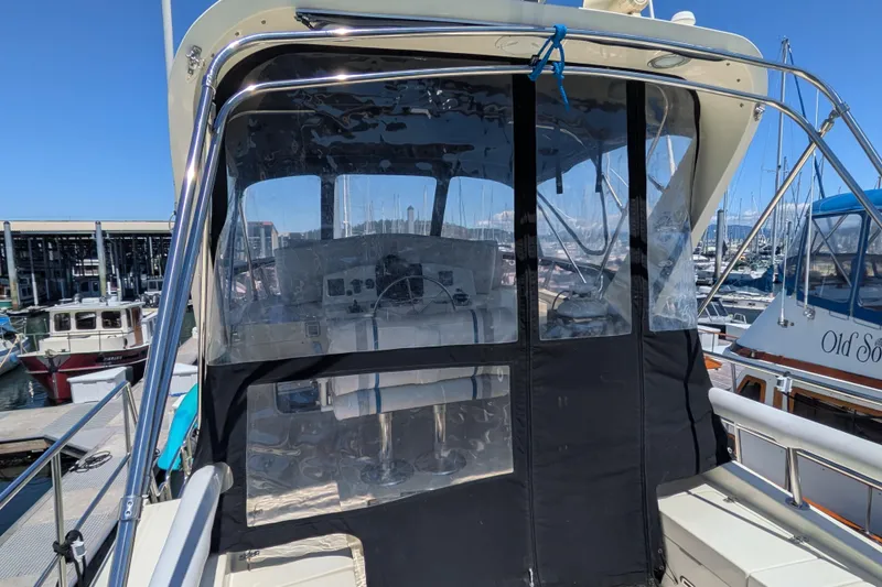 Slide: The Image of 2006 North Pacific 42 Pilothouse boat docked at marina, featuring enclosed helm area. - 14