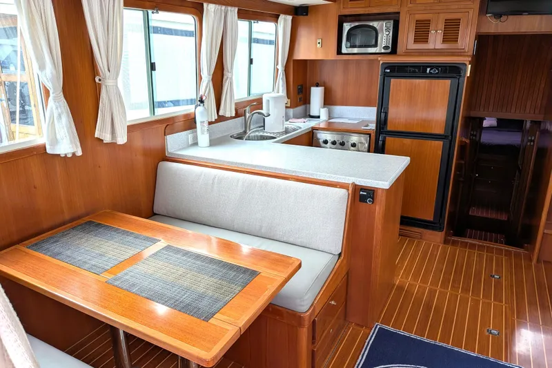 Slide: The Image of Interior of 2006 North Pacific 42 Pilothouse with kitchen and dining area. - 19