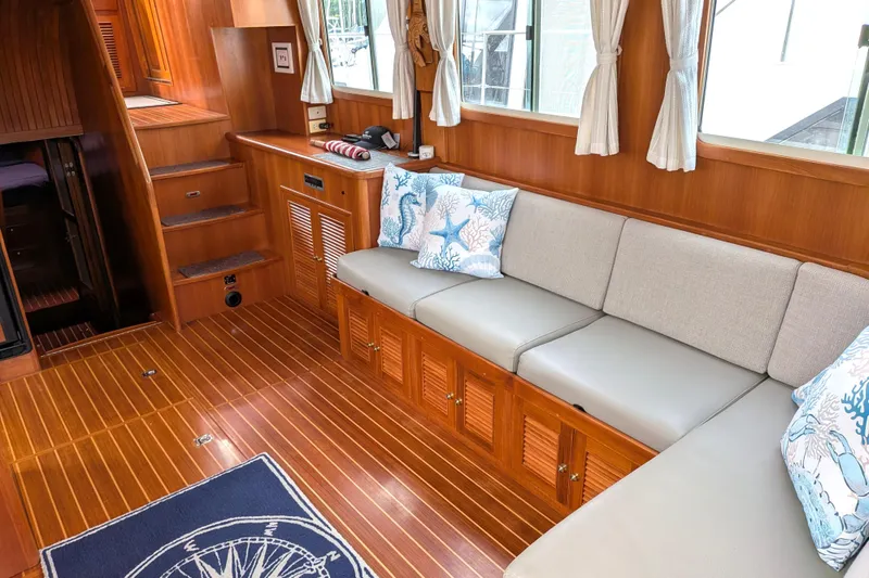 Slide: The Image of Interior of 2006 North Pacific 42 Pilothouse with wooden flooring and cushioned seating. - 20