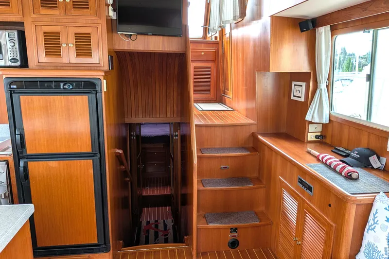 Slide: The Image of Interior of 2006 North Pacific 42 Pilothouse with wooden cabinetry and stairs. - 21