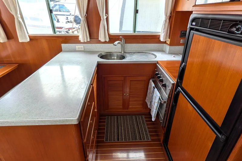 Slide: The Image of Galley kitchen in 2006 North Pacific 42 Pilothouse with wood cabinetry and modern appliances. - 24