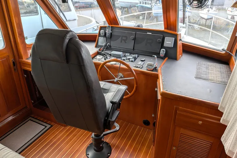 Slide: The Image of Pilothouse interior of 2006 North Pacific 42, featuring helm station and captain's chair. - 27
