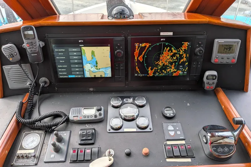 Slide: The Image of Pilothouse dashboard of a 2006 North Pacific 42, featuring navigation and communication equipment. - 31
