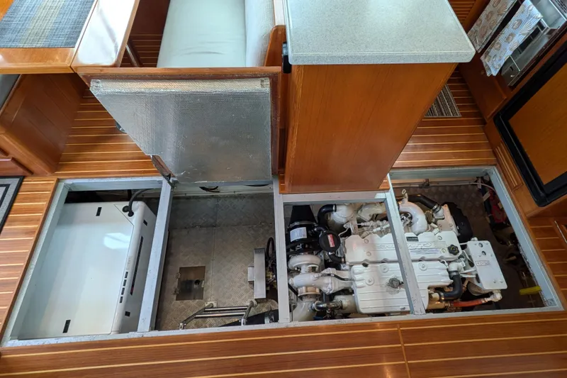 Slide: The Image of Engine room of 2006 North Pacific 42 Pilothouse yacht with visible machinery and wooden flooring. - 38