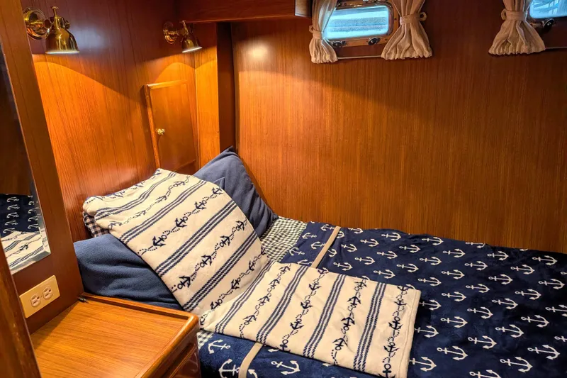 Slide: The Image of Cozy cabin interior of 2006 North Pacific 42 Pilothouse with nautical-themed bedding. - 42