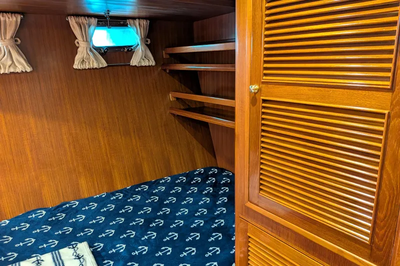 Slide: The Image of Cozy cabin interior of 2006 North Pacific 42 Pilothouse with wooden finish and nautical bedding. - 43