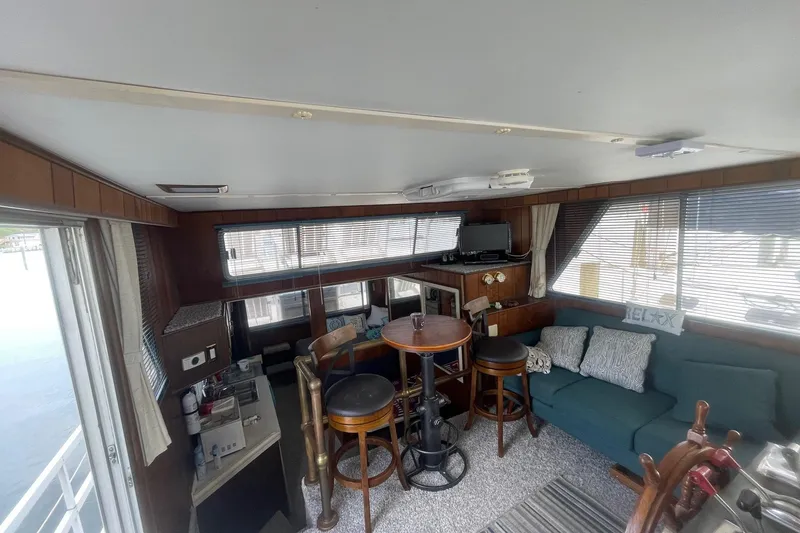 Slide: The Image of Interior of a 1991 Gibson 37 Standard Houseboat with cozy seating and dining area. - 12