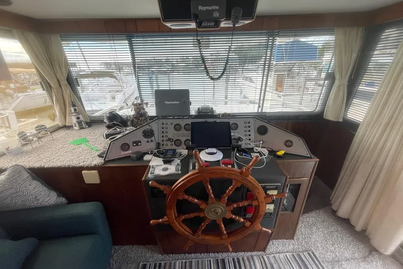 Slide: The Image of 1991 Gibson 37 Standard Houseboat helm with wooden wheel and navigation equipment. - 15