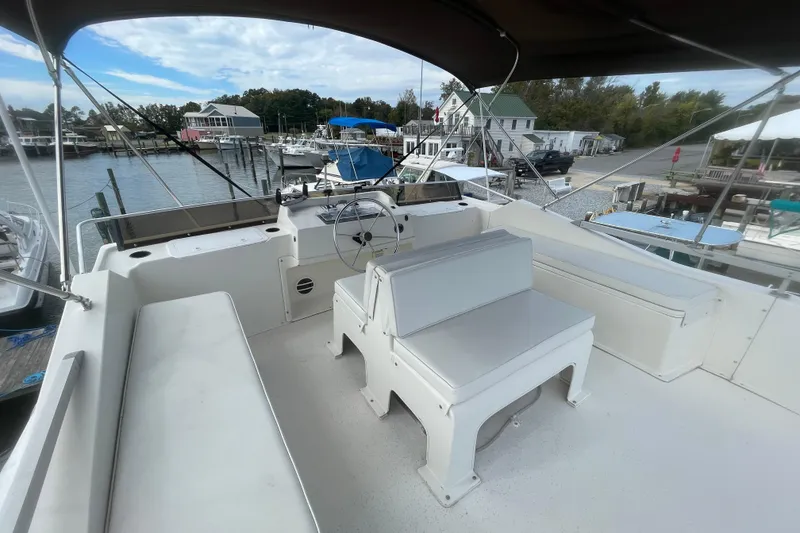 Slide: The Image of 1991 Gibson 37 Standard Houseboat helm with seating, docked at a marina. - 24