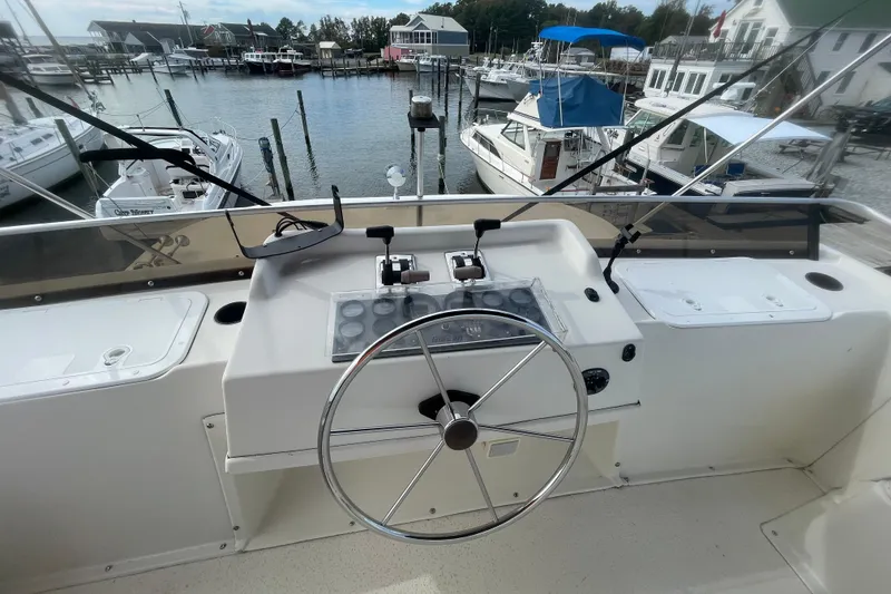 Slide: The Image of Helm of 1991 Gibson 37 Standard Houseboat at marina, featuring steering wheel and controls. - 25