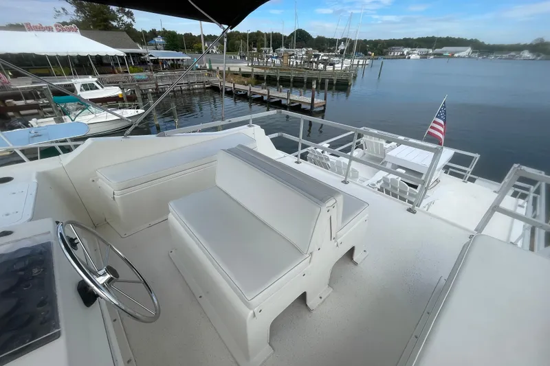 Slide: The Image of 1991 Gibson 37 Standard Houseboat with seating area, docked at a marina with scenic water views. - 26