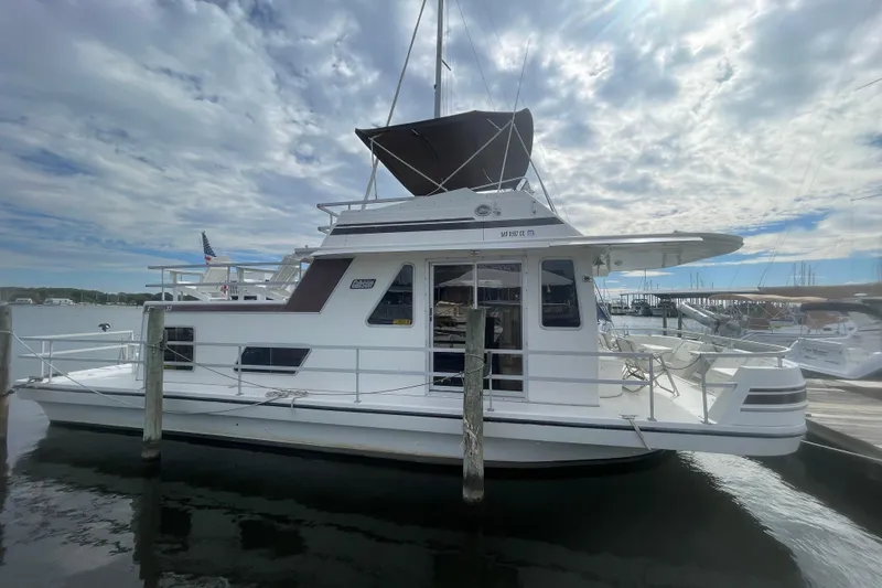 Slide: The Image of 1991 Gibson 37 Standard Houseboat docked under a cloudy sky. - 3