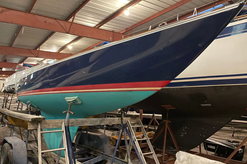 Slide: The Image of 1965 Chris Craft Shields sailboat in storage, showcasing sleek blue and turquoise hull design. - 2