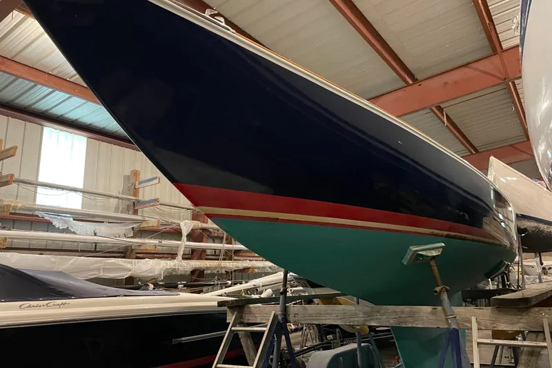 Slide: The Image of 1965 Chris Craft Shields sailboat in storage, showcasing sleek hull design and vibrant colors. - 3