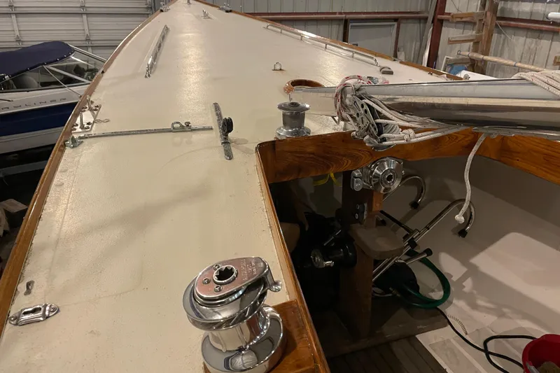 Slide: The Image of 1965 Chris Craft Shields sailboat deck with rigging and winch in a storage facility. - 9