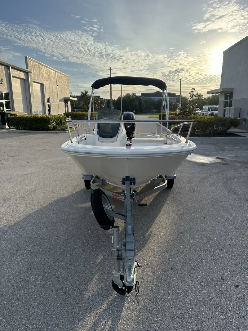 Slide: The Image of 2025 Boston Whaler 130 Super Sport boat on trailer at sunset. - 2