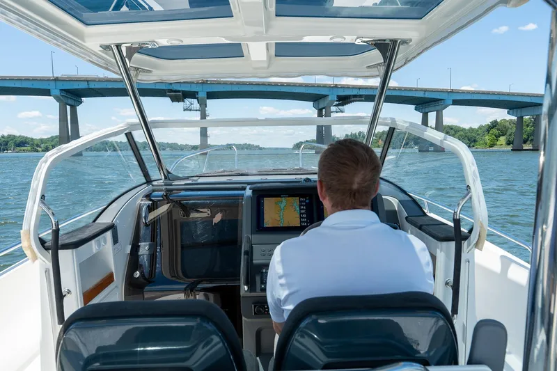 Slide: The Image of Man piloting 2023 Nimbus Tender 9 under bridge. - 10