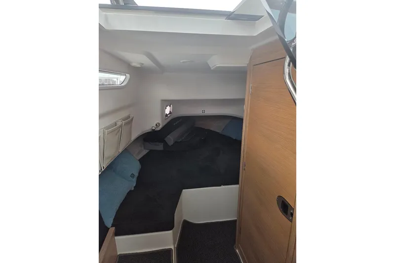 Slide: The Image of 2023 Nimbus T9 cabin interior with cozy sleeping area and wooden door. - 26