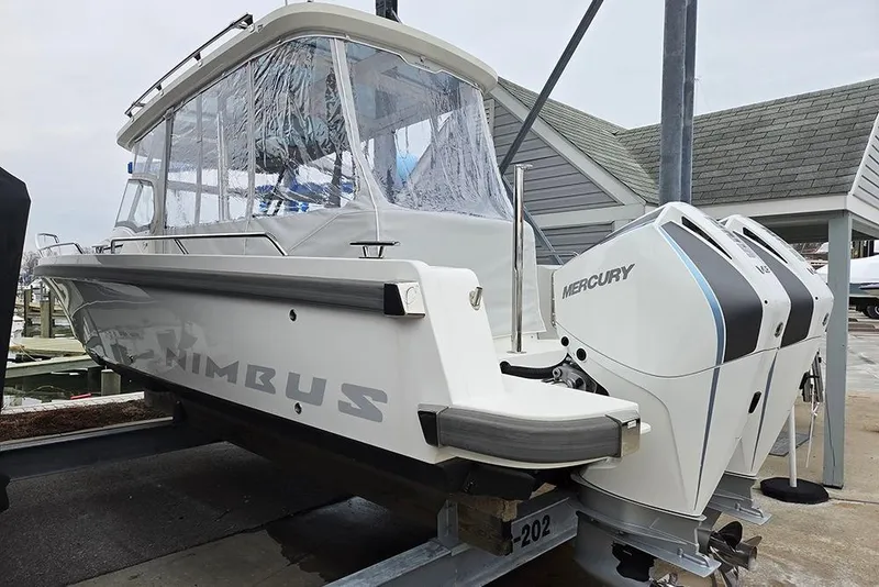 Slide: The Image of 2023 Nimbus T9 boat with dual Mercury engines on a dock. - 29
