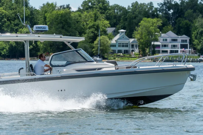 Slide: The Image of Nimbus Tender 9 boat 2023 on a lake with houses in background. - 7