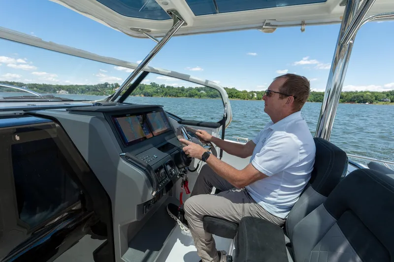 Slide: The Image of Man piloting 2023 Nimbus Tender 9 on a lake. - 9