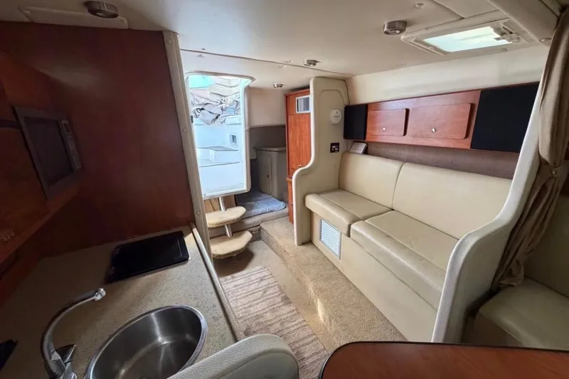 Slide: The Image of Interior of a 2006 Rinker 300 Express Cruiser with kitchenette and seating area. - 11
