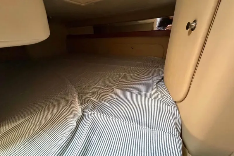 Slide: The Image of Interior cabin of 2006 Rinker 300 Express Cruiser with striped bedding. - 12