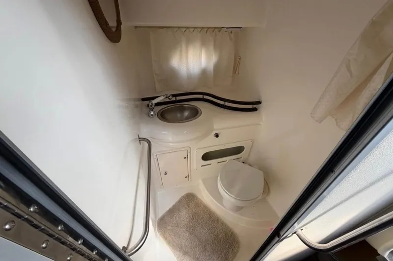 Slide: The Image of 2006 Rinker 300 Express Cruiser bathroom with sink, toilet, and curtain. - 14
