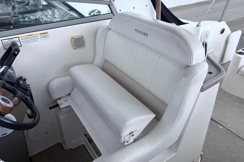 Slide: The Image of 2006 Rinker 300 Express Cruiser helm with white leather seating and steering wheel. - 20