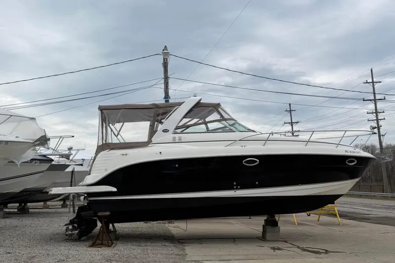 Slide: The Image of 2006 Rinker 300 Express Cruiser boat on dry dock, black and white exterior. - 3