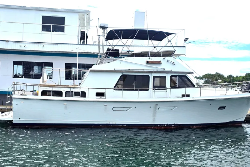 The Image of 1991 Marine Trader Trawler docked, white boat with blue canopy. - 0