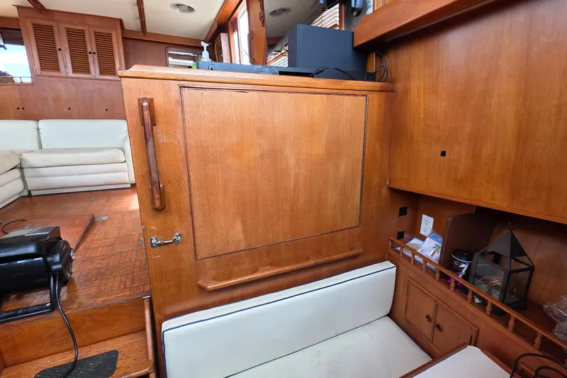 Slide: The Image of Interior of a 1991 Marine Trader Trawler with wooden cabinetry and seating area. - 10