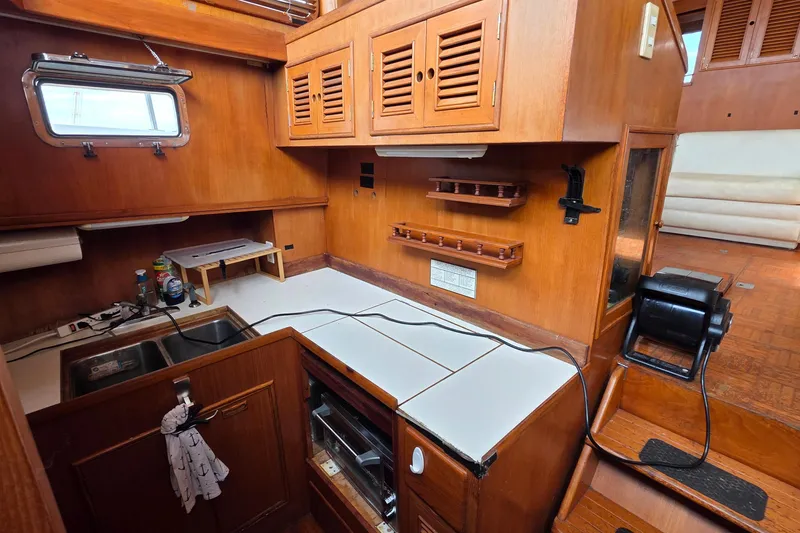 Slide: The Image of 1991 Marine Trader Trawler kitchen with wooden cabinetry, sink, and appliances. - 12