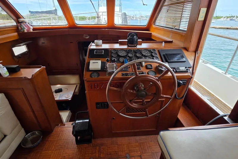 Slide: The Image of 1991 Marine Trader Trawler helm with wooden steering wheel and navigation instruments. - 14