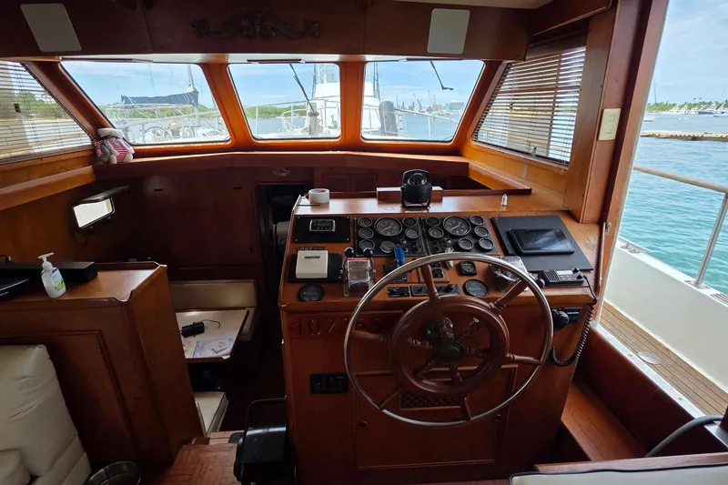 Slide: The Image of 1991 Marine Trader Trawler helm with wooden steering wheel and navigational instruments. - 17