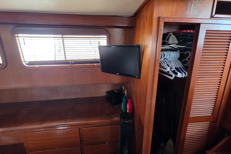 Slide: The Image of Interior of 1991 Marine Trader Trawler with wooden cabinetry, TV, and closet space. - 26