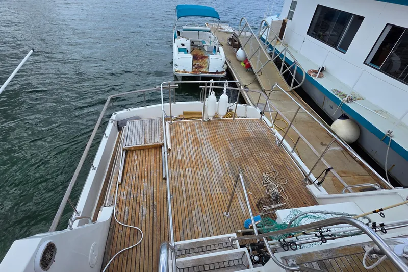 Slide: The Image of 1991 Marine Trader Trawler with wooden deck, docked beside another boat. - 33