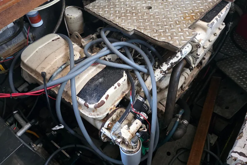 Slide: The Image of Engine compartment of a 1991 Marine Trader Trawler, featuring cables and metal components. - 34