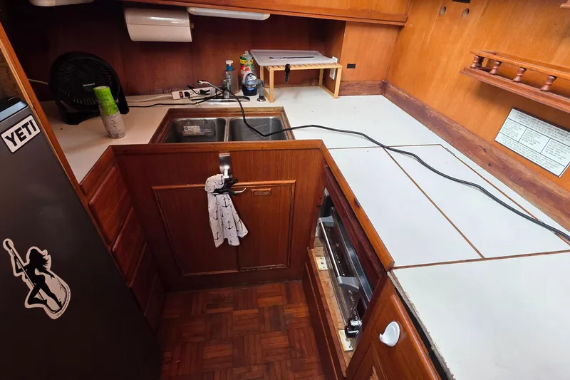 Slide: The Image of 1991 Marine Trader Trawler kitchen with wooden cabinetry and sink area. - 8