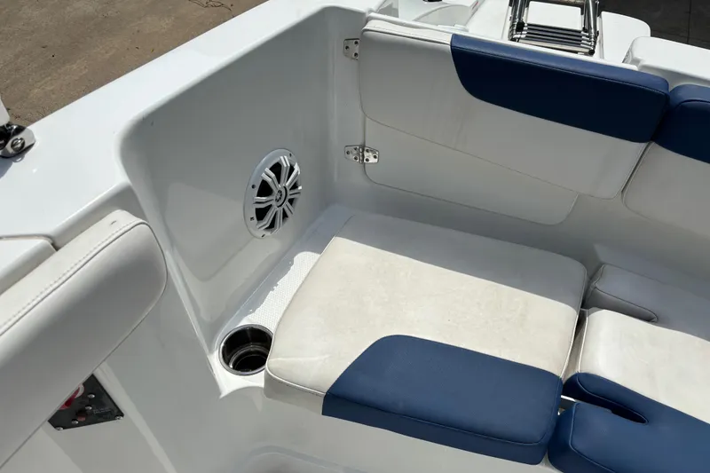 Slide: The Image of 2020 Tahoe 2150 CC boat interior with blue and white seating, speaker, and cup holder. - 19