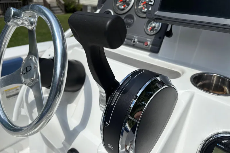 Slide: The Image of Close-up of 2020 Tahoe 2150 CC boat controls, featuring steering wheel and throttle lever. - 22