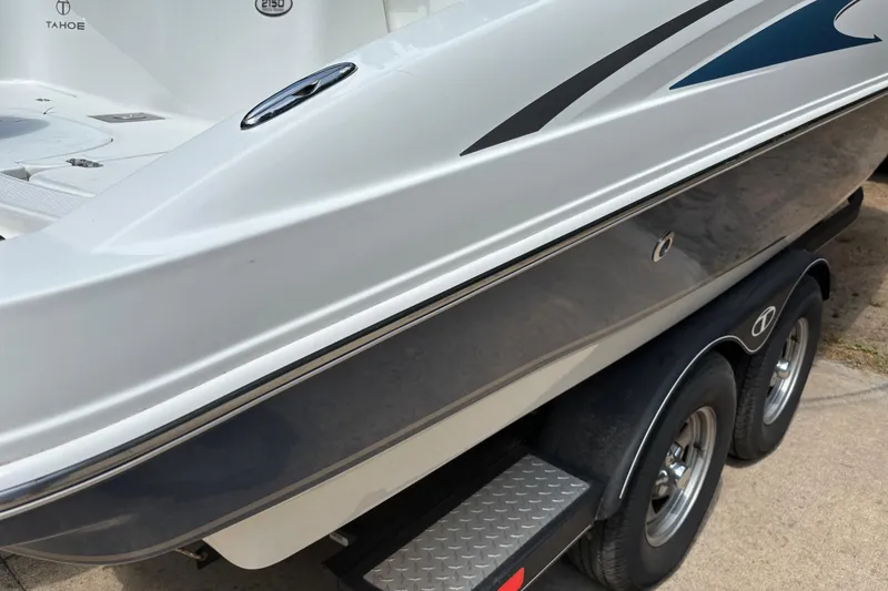 Slide: The Image of 2020 Tahoe 2150 CC boat on trailer, showcasing sleek design and dual wheels. - 27